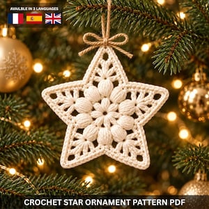 May include: A cream-colored crochet star ornament featuring a textured, floral-inspired center with puff stitches and a delicate openwork border. The star is suspended by a matching twine loop tied in a small bow at the top of the ornament.