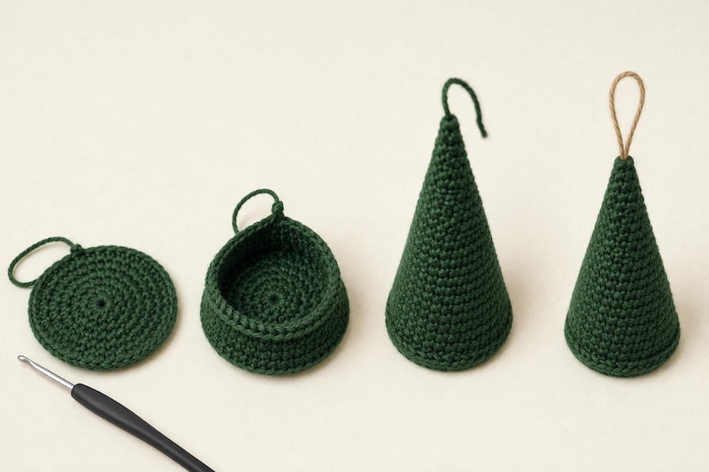 May include: A set of dark green crocheted items including a flat circular piece, a small bowl-like container, and two cone-shaped ornaments with hanging loops, accompanied by a metal crochet hook with a black handle for crafting these pieces.