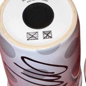 Pu&ograve; includere: Una tazza Disney in ceramica bianca con base nera. La tazza presenta un design di ovali grigi e rossi e linee astratte nere. Il fondo della tazza riporta la scritta "DISNEY MADE IN THAILAND" e simboli per microonde.