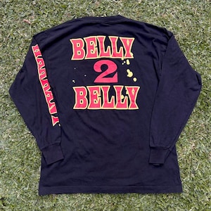 May include: Black long-sleeved shirt with a yellow and red graphic print that says "Belly 2 Belly".