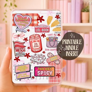 Peut inclure: Un insert Kindle transparent avec divers autocollants, dont un panneau en forme de cœur indiquant « Enemies to Lovers Lodge », un drapeau rouge et un pot avec l'inscription « Burn After Reading ». L'insert contient également le texte « Printable Kindle Insert ».