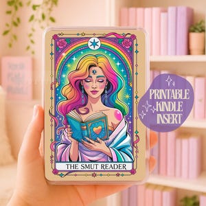 Op de afbeelding: Kindle-inzet met een kleurrijke illustratie van een vrouw met regenbooghaar die een boek leest. De afbeelding heeft een regenboogboog en de tekst "THE SMUT READER". Een paarse sticker zegt "PRINTABLE KINDLE INSERT".