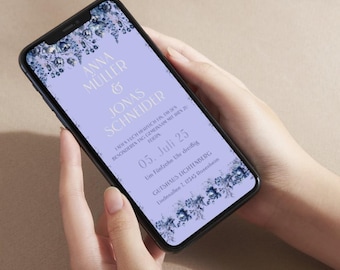 以下が含まれることがあります： スマートフォンには、Anna Müller & Jonas Schneiderの名前が書かれた結婚式の招待状が表示されています。招待状には花の装飾と薄紫色のテキストが施されています。日付は7月5日で、時間と場所も表示されています。
