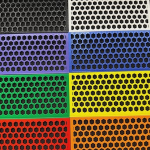 May include: A collection of rectangular honeycomb-patterned panels in various colors, including black, white, purple, blue, green, yellow, orange, and red. The panels are made of a solid material and feature a repeating hexagonal design.