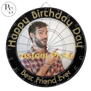 Op de afbeelding: Een gepersonaliseerd dartbord met een foto van een persoon in een geruit overhemd. Het zwarte dartbord heeft de woorden "Happy Birthday" en "Best Friend Ever" in gouden letters. Het midden van het dartbord zegt "Custom Picture".