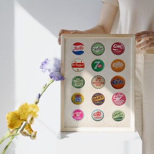 Retro soda bottle cap wall art digital print featuring colorful vintage-style caps from popular brands like Coke, Pepsi, Sprite, 7Up, and Fanta. This 24x36 inch pop art-inspired design is perfect for nostalgic home decor, man caves, kitchens, or soda lovers’ collections. Digital download includes high-resolution artwork for easy printing.
