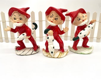 Trio of pixie gnome elves holding polkadot umbrella