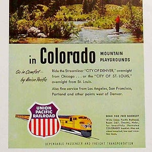 May include: A vintage travel poster advertising train travel to Colorado's mountain playgrounds. The poster features a scenic image of a river flowing through a forest, a train, and the Union Pacific Railroad logo. The text reads "Go in Comfort... by Union Pacific" and "Mountain Playgrounds in Colorado".