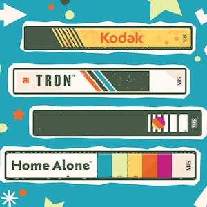 Puede incluir: Ilustración de cuatro cintas VHS con los títulos "Kodak", "TRON" y "Home Alone". Las cintas están sobre un fondo verde azulado con formas de estrellas y flechas. La cinta "Kodak" es amarilla y naranja. La cinta "TRON" tiene rayas azules, naranjas y blancas.