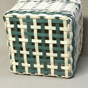 Peut inclure: Un panier carr&eacute; tiss&eacute; avec un motif &agrave; carreaux vert et blanc. Le panier est fait de mat&eacute;riaux naturels et a un aspect rustique.
