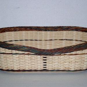 May include: A set of three ceramic nesting bowls in graduating sizes. The bowls are white with a blue floral pattern and a scalloped edge. The largest bowl is approximately 8 inches in diameter.