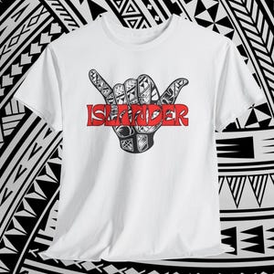 May include: White t-shirt with a black and red graphic of a hand gesture with detailed patterns. The word "ISLANDER" is printed in red across the hand. The shirt is set against a black and white patterned background.