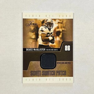 May include: A 2003 Flair NFL trading card featuring Deuce McAllister of the New Orleans Saints. The card displays a sepia-toned photograph of the player, the text "Sweet Swatch Patch," and an embedded black fabric piece labeled as an authentic game-worn patch.