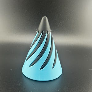 May include: A 3D-printed, cone-shaped object with a black top and a light blue base. The design features black, curved, vertical cutouts that create a spiral effect around the cone. The object is displayed against a dark background.