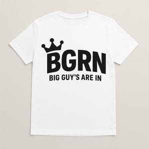 Puede incluir: Camiseta blanca con una corona negra y el texto "BGRN BIG GUY'S ARE IN"