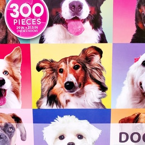 May include: A jigsaw puzzle featuring a collage of dog portraits. The puzzle has 300 pieces and measures 29 inches by 21.5 inches (75cm x 50cm). The dogs are set against colorful backgrounds, with the word "DOG" visible.