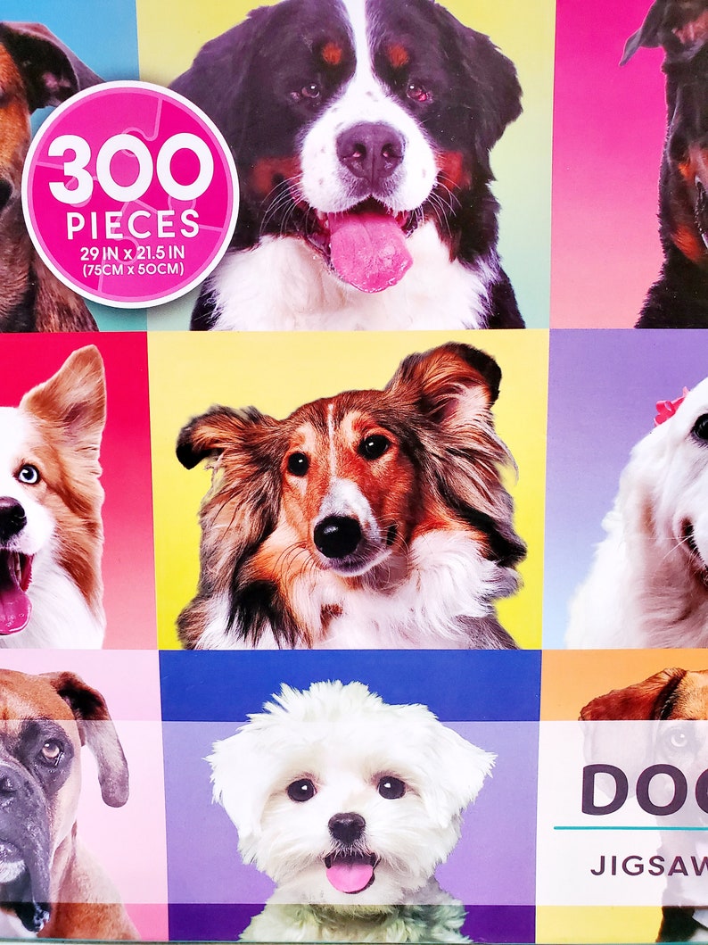 May include: A jigsaw puzzle featuring a collage of dog portraits. The puzzle has 300 pieces and measures 29 inches by 21.5 inches (75cm x 50cm). The dogs are set against colorful backgrounds, with the word "DOG" visible.