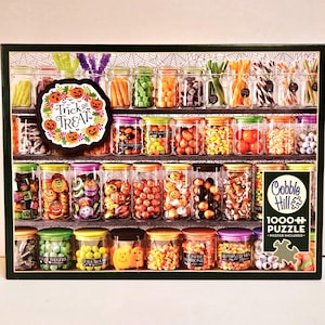May include: A Halloween-themed puzzle featuring jars filled with various candies and treats. The puzzle includes the text "Trick or Treat" and "Cobble Hill 1000+ Puzzle". The jars are arranged on shelves, creating a colorful and festive image.