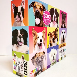 May include: A colorful jigsaw puzzle box featuring a collage of dog portraits. The box displays the text "300 PIECES" and "DOGS JIGSAW PUZZLE". The puzzle measures 29 inches by 21.5 inches.