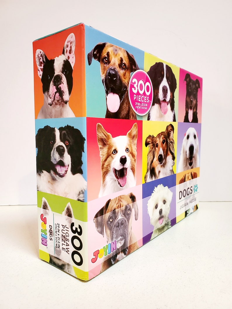 May include: A colorful jigsaw puzzle box featuring a collage of dog portraits. The box displays the text "300 PIECES" and "DOGS JIGSAW PUZZLE". The puzzle measures 29 inches by 21.5 inches.