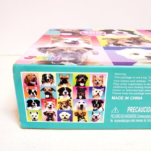 May include: A colorful box featuring a grid of dog portraits. The box has a teal border and the text "JOYIN" is visible. The box also includes a warning label and the text "MADE IN CHINA".