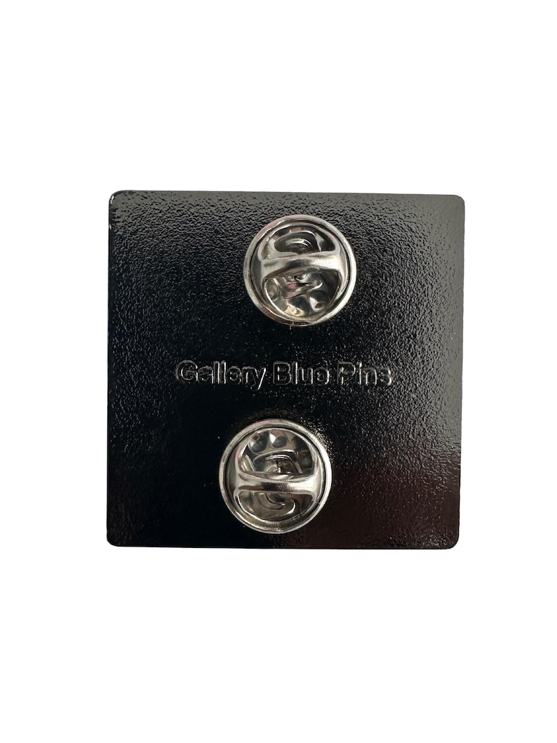 Back of hard enamel pin with two vertical pin posts and back stamp.