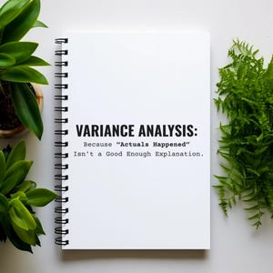 May include: A white spiral-bound notebook with the text "VARIANCE ANALYSIS: Because "Actuals Happened" Isn't a Good Enough Explanation." Green plants in pots and a fern are arranged around the notebook on a white surface.