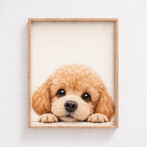 Puede incluir: Una impresión enmarcada que presenta un cachorro marrón claro con ojos grandes y oscuros y una nariz negra. Las patas del cachorro descansan en el borde inferior del marco, creando una imagen encantadora. El marco es de madera clara.