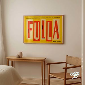 May include: A framed poster with the word "FULLA" in large, red, block letters against a yellow background. The poster also features text in a smaller font. The poster is displayed on a white wall.