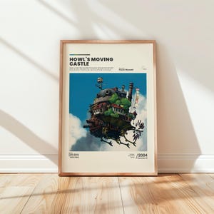 May include: Framed poster featuring the text "Howl's Moving Castle" above an illustration of the castle in the sky. The artwork depicts a whimsical, multi-layered structure with a blue sky and white clouds in the background. The poster is in a wooden frame.