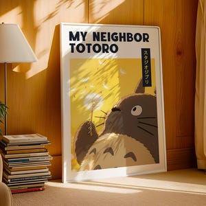 Pode incluir: Um poster emoldurado do filme de anima&ccedil;&atilde;o "Meu Vizinho Totoro". A arte mostra Totoro segurando um dente-de-le&atilde;o contra um fundo amarelo. O poster tem o t&iacute;tulo do filme em ingl&ecirc;s e japon&ecirc;s.