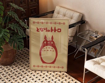 May include: A rectangular framed wall art print featuring a cream background with a red illustration of the character Totoro. The design includes red Japanese text that reads となりのトトロ above the character and decorative red floral borders at the top and bottom of the print.