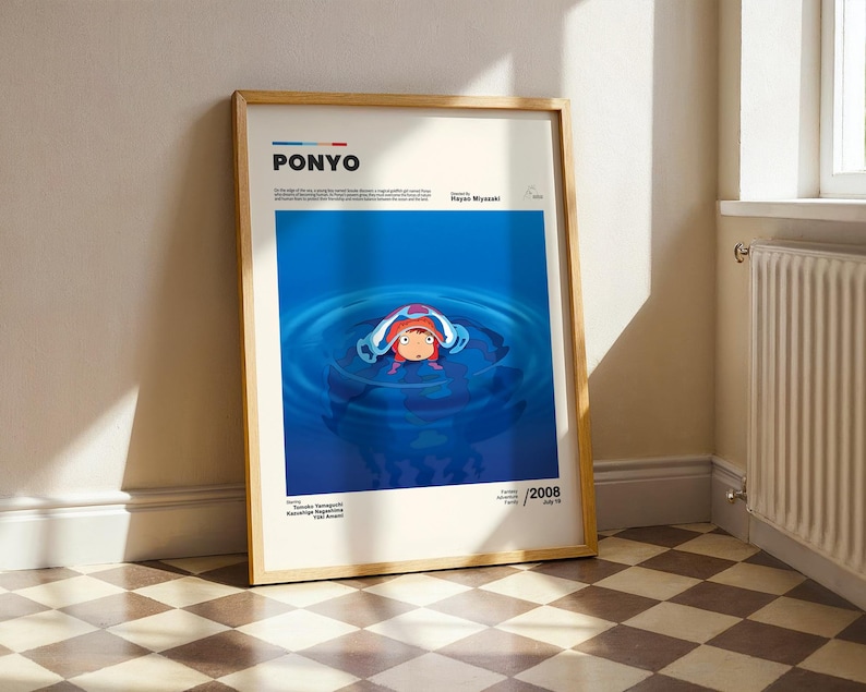 Op de afbeelding: Een ingelijste poster met de animatiefilm "Ponyo". Het kunstwerk toont een personage in een blauwe wateromgeving. De poster heeft een houten lijst en bevat de titel van de film en het jaar van uitgave.