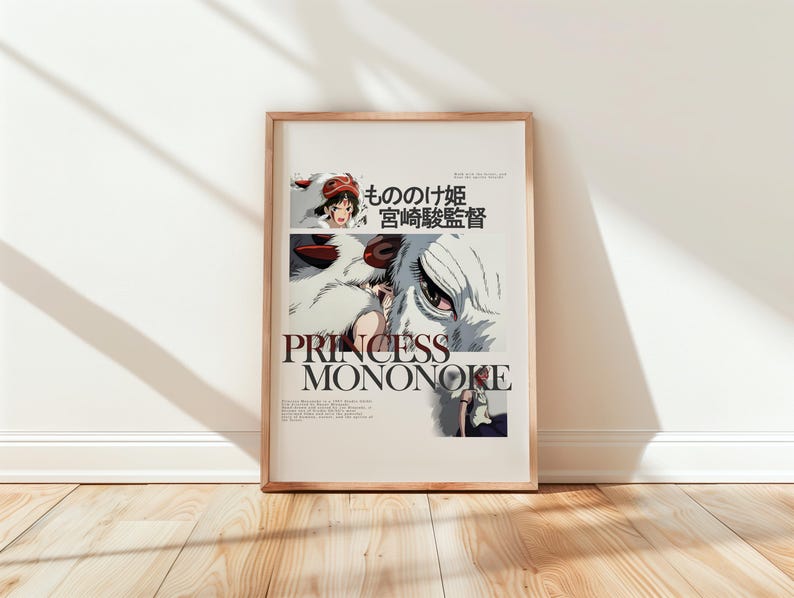 May include: A framed poster featuring the title "PRINCESS MONONOKE" in large, bold letters. The artwork includes illustrations of characters and a wolf-like creature. Japanese text is also present. The poster is displayed against a white wall and wooden floor.