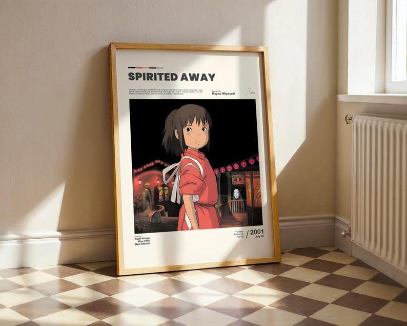 May include: Framed poster featuring the animated film "Spirited Away." The artwork depicts a young girl in a red outfit against a dark background with illuminated buildings. The poster has a wooden frame and includes the film's title and year of release.