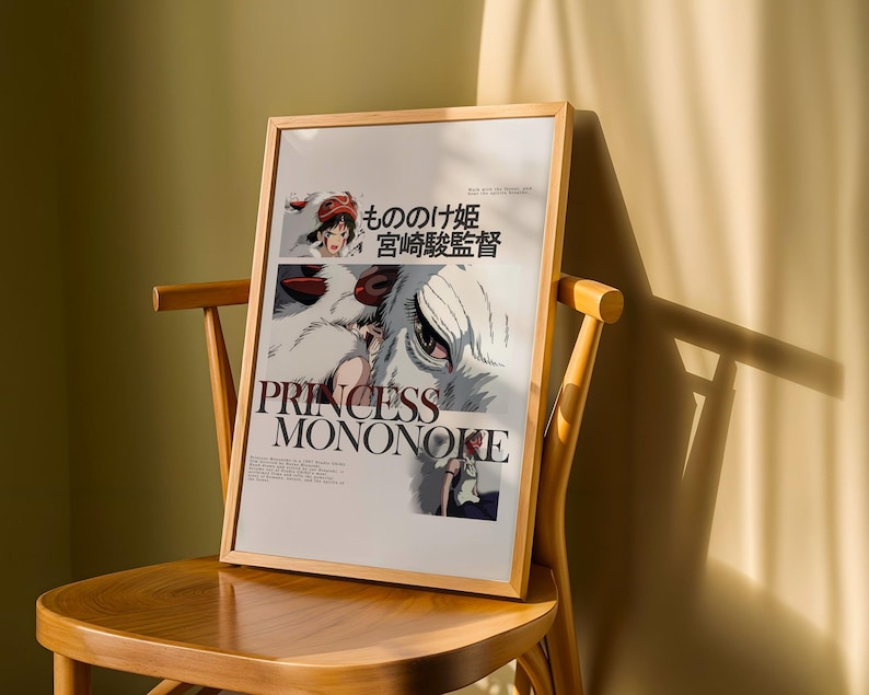 May include: A framed poster of the animated film "Princess Mononoke" rests on a wooden chair. The poster features the film's title in English and Japanese, along with character illustrations. The frame is a light wood color.