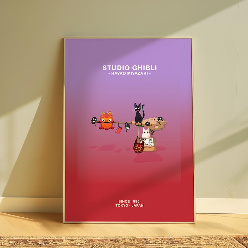 May include: A framed poster with a gradient background of purple and red. The poster features cartoon characters and the text "STUDIO GHIBLI - HAYAO MIYAZAKI - SINCE 1985 TOKYO - JAPAN". The artwork includes a fiery creature, black cat, and other whimsical elements.