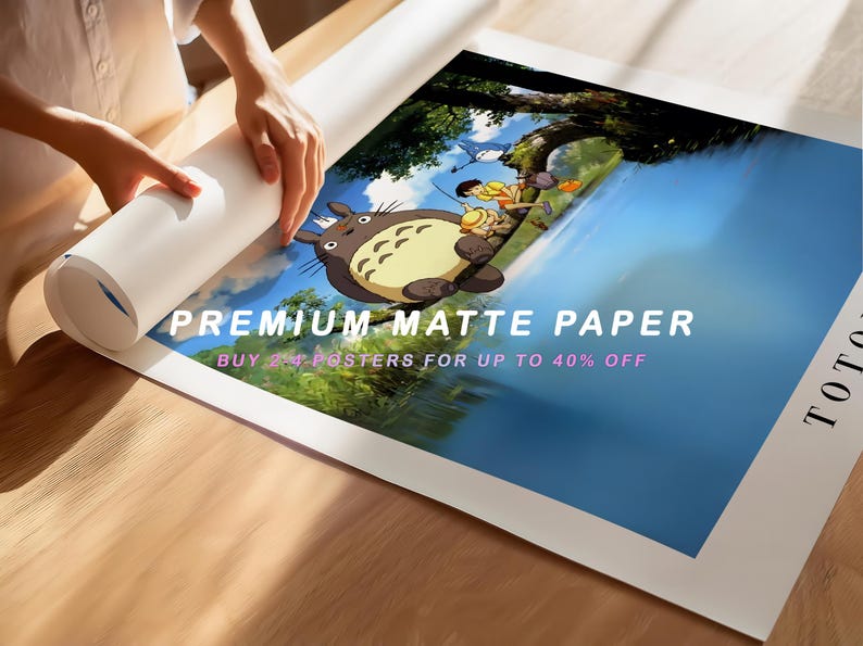 May include: A rolled-up poster featuring a scene with a large, gray cartoon character and two children near a body of water. The poster is being unrolled on a wooden surface. Text on the poster reads "PREMIUM MATTE PAPER".