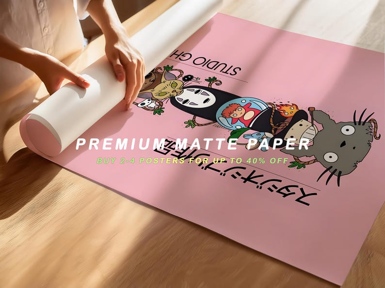 Puede incluir: Un p&oacute;ster rosa con personajes de una pel&iacute;cula de animaci&oacute;n japonesa. El p&oacute;ster tiene texto japon&eacute;s y las palabras "PREMIUM MATTE PAPER". Una persona est&aacute; desenrollando el p&oacute;ster sobre una superficie de madera.