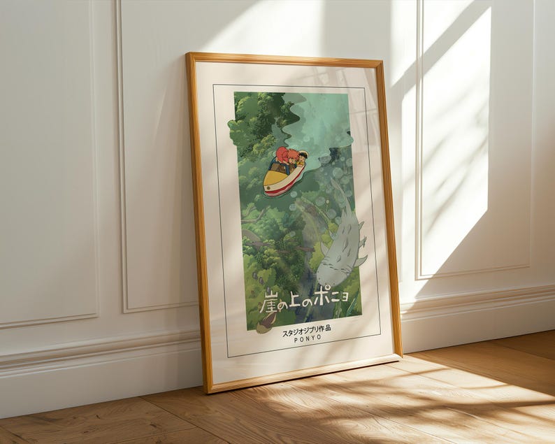 May include: A framed art print of the animated film "Ponyo." The image shows a yellow boat with two figures, a large fish, and green foliage. The print has a light border and a wooden frame. The Japanese title is visible.