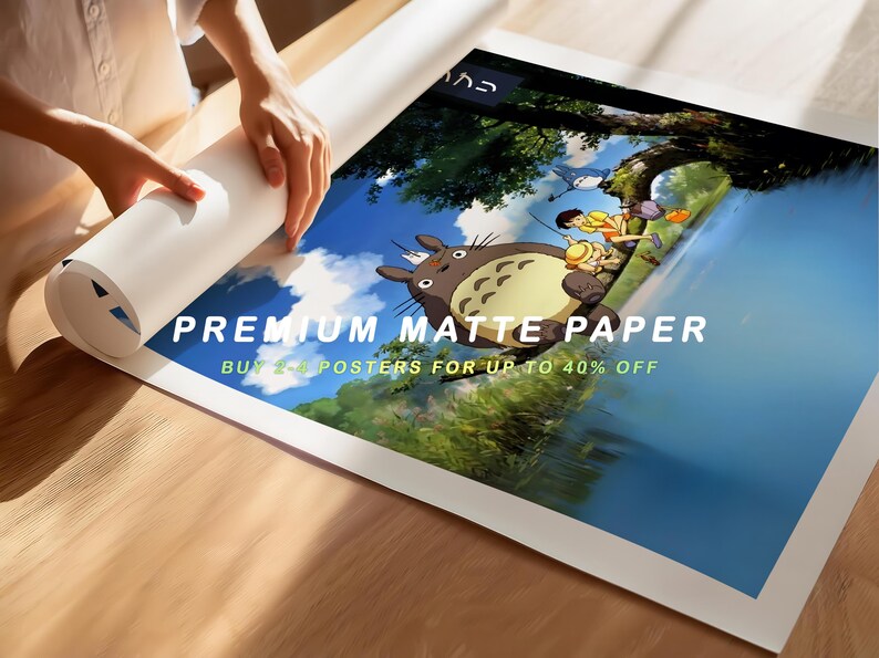 May include: A person unrolling a poster featuring an animated scene with a large, furry creature and other characters. The poster is printed on premium matte paper. Text on the poster reads "BUY 2+ POSTERS FOR UP TO 40% OFF".