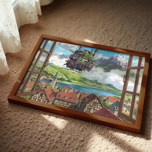 May include: A framed print showing a colourful landscape with a village, lake, and mountains. A fantastical floating castle is in the sky. The image is viewed through a wooden window frame. The rooftops are red-tiled.