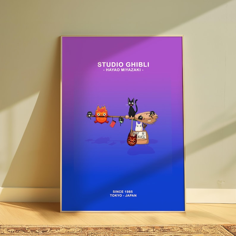 May include: A framed poster with a gradient purple to blue background. The poster features Studio Ghibli characters, including a black cat, a white cat, and a fiery creature. Text at the top reads "STUDIO GHIBLI - HAYAO MIYAZAKI -" and at the bottom "SINCE 1985 TOKYO - JAPAN."