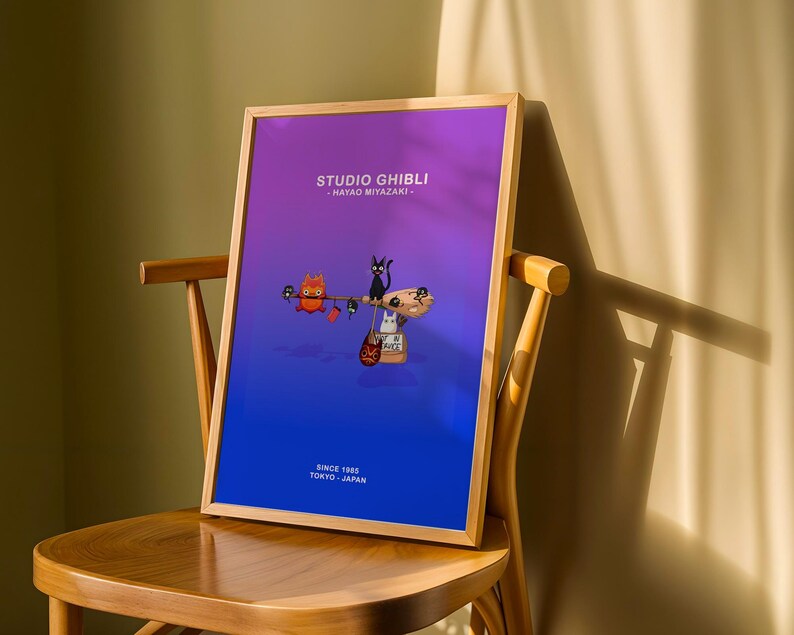 May include: A framed poster featuring Studio Ghibli characters against a gradient purple and blue background. The poster includes the text "STUDIO GHIBLI - HAYAO MIYAZAKI" and "SINCE 1985 TOKYO - JAPAN". The poster is displayed on a wooden chair.