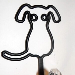 May include: Black metal dog hook with a clear crystal knob. The hook is shaped like a cartoon dog with large ears and a simple body.