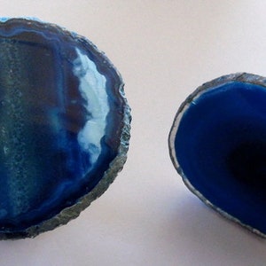 May include: Two blue agate slices, one with a white swirl pattern, the other solid blue, mounted on metal bases. The agate slices are approximately 3 inches in diameter.