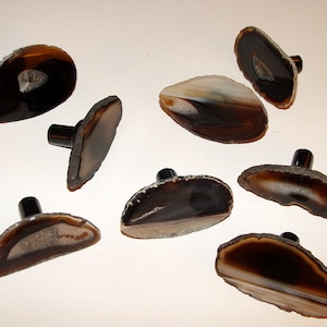 May include: Eight agate slice cabinet knobs with black metal bases. The agate slices are in shades of brown, black, and white.
