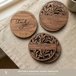 May include: Round wooden wedding favour coasters. One coaster has the text "Thank you" and the date. Other coasters are engraved with "JASHPER & KAREN" and the wedding date. The coasters feature laser-cut leaf designs. The coasters are made of wood.