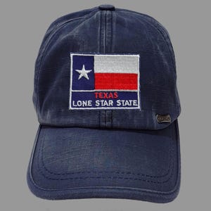 May include: A dark blue baseball cap with a distressed look. The front of the cap features an embroidered patch with the Texas flag and the text "Texas Lone Star State".