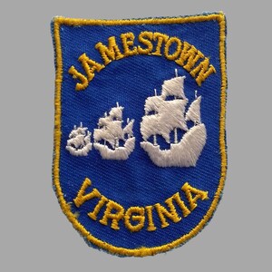 May include: A blue and yellow embroidered patch with the text "JAMESTOWN VIRGINIA" and a white embroidered image of three sailing ships.
